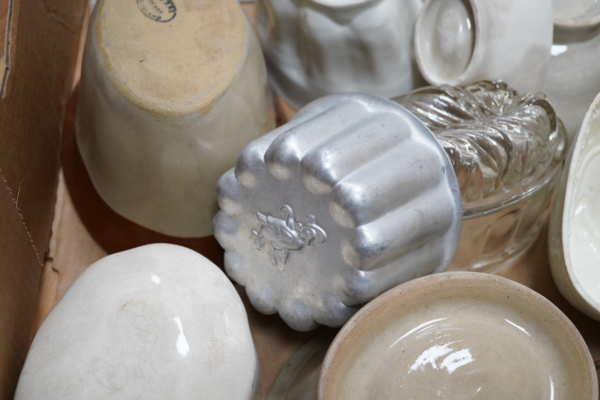 A collection of mostly Victorian ceramic and later glass and metal jelly moulds